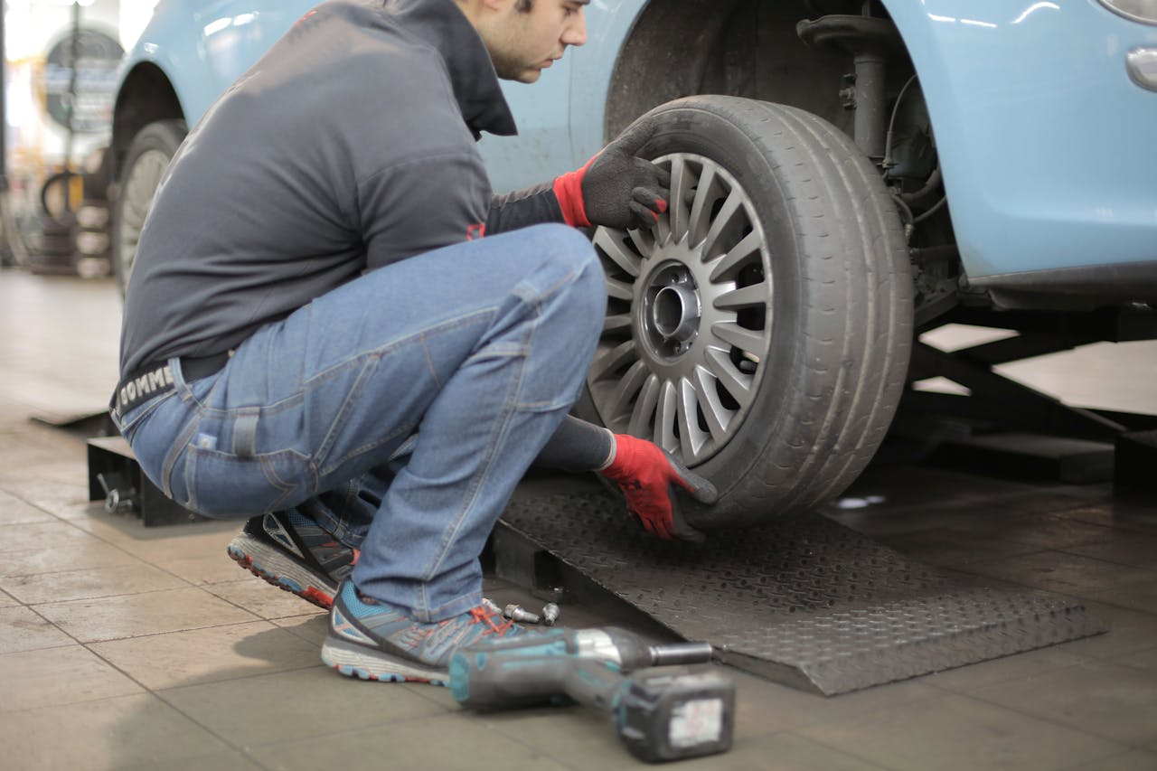 A boy changing the tyre of a car