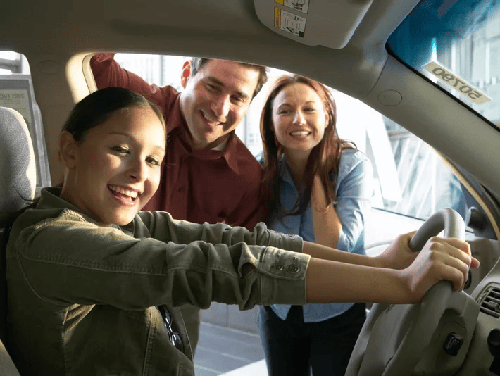 A smiling girl behind the wheel